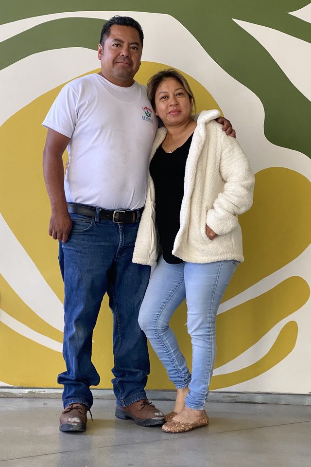 Yesenia and Oscar, owners of California Refresh, standing together in front of a colorful mural